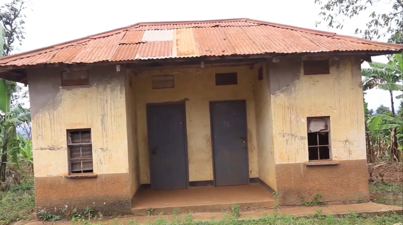 The old midwife house at Kyebe before the rebuild: rusted roof, broken windows, stained walls